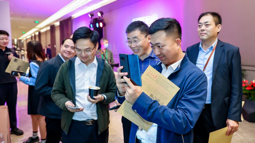 人民網(wǎng)研發(fā)推出的《人民日?qǐng)?bào)》生日?qǐng)?bào)吸引嘉賓體驗(yàn)。主辦方供圖