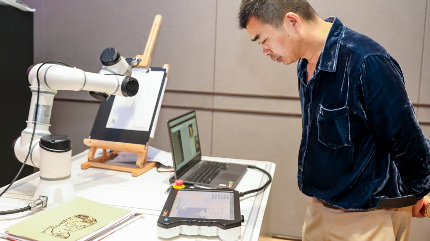 嘉賓體驗(yàn)遨博AI繪畫機(jī)器人。主辦方供圖